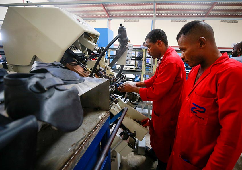 Workers operate a machine at a Bata shoe factory in Abuja, Nigeria