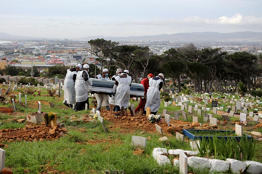 Family members and funeral workers carry the coffin of a man who died from the coronavirus disease, at a cemetery in Cape Town, South Africa, on May 12, 2020