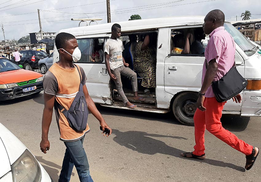 A man wears a protective mask as he walks on a street in Abidjan, Cote d’Ivoire.