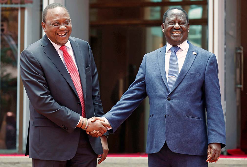 Kenyan President Uhuru Kenyatta (L) shakes hands with opposition leader Raila Odinga of the National Super Alliance coalition after a news conference at the Harambee House office in Nairobi on March 9, 2018.