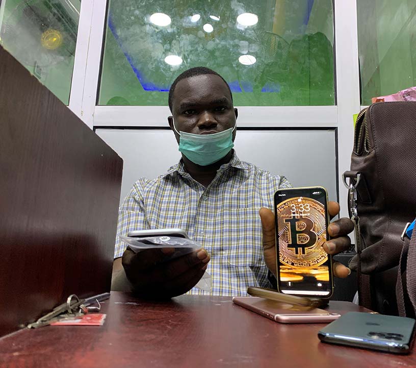A gadget vendor who trades with bitcoin displays a bitcoin application on his mobile phone in Lagos, Nigeria.