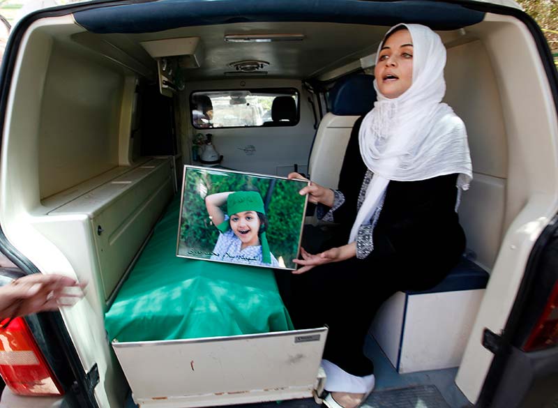 A woman shows a picture of her daughter, who was killed by NATO air strikes in June 2011 in Surman, west of Tripoli.