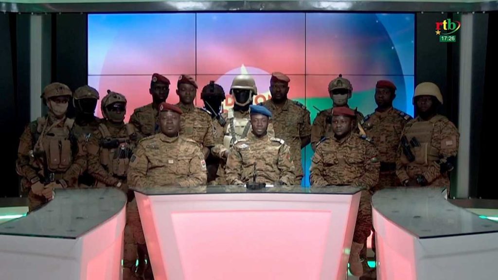 Captain Sidsore Kader Ouedraogo, center, spokesman for Burkina Faso’s new military government, with uniformed soldiers from the Patriotic Movement for Safeguard and Restoration, announces from a television studio that they have taken power, deposing President Roch Kabore. The broadcast came after two days of fighting in Ouagadougou, the capital.