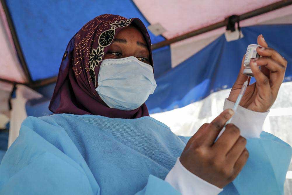 A nurse prepares to administer an AstraZeneca vaccination against COVID-19 at a district health center in the low-income Kibera neighborhood of Nairobi, Kenya on Jan. 20. At least 2.8 million doses of COVID-19 vaccines donated to African countries expired before they could be used, the Africa Centers for Disease Control said.