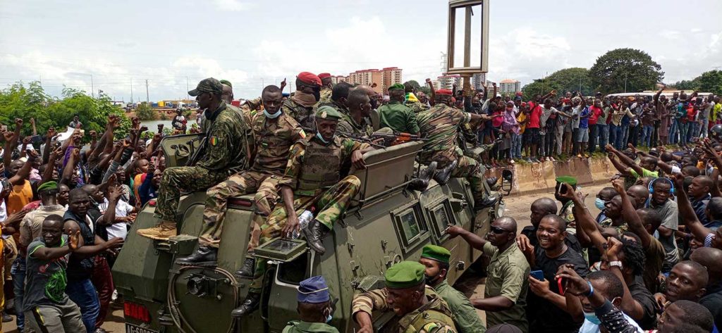 Conakry residents cheer Guinean Army soldiers in the city’s streets on September 6, the day after the coup that toppled President Alpha Conde.