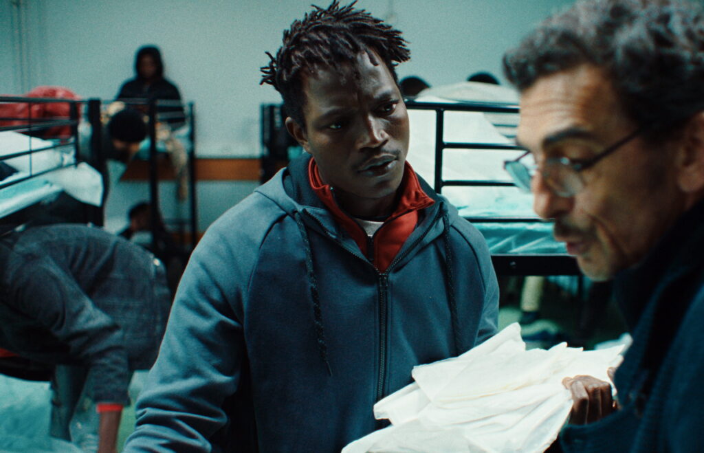 Abou Sangaré plays Souleymane, who juggles working as a bicycle deliveryman under someone else’s name while trying to win asylum in France. Sangaré, like his character, is also a Guinean immigrant to Paris.