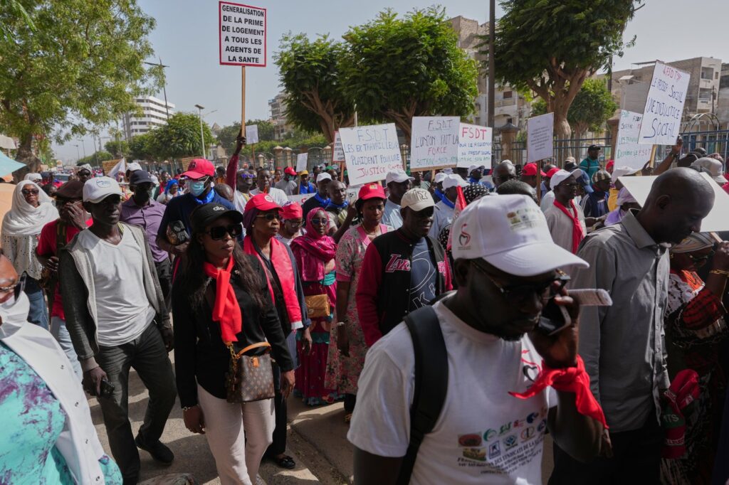 Workers hold placards as they march to demand that the government honor its commitments and address their concerns in Dakar, Senegal, on April 8, 2026.  