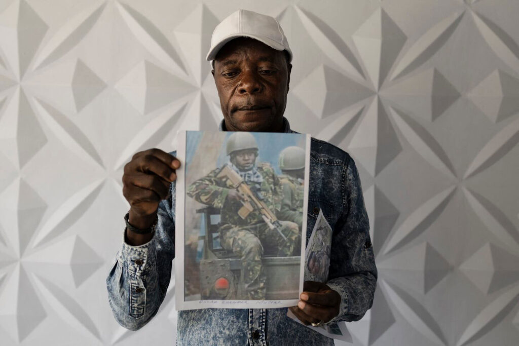 Charles Ojiambo Mutoka, 72, stands with pictures of his son Oscar during a press conference in Nairobi in January. Oscar was killed in August 2025 while fighting alongside Russian soldiers against Ukraine.
