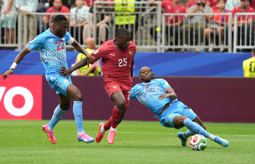 Portuguese defender Nuno Mendes, center, drives between Democratic Republic of the Congo defenders Chancel Mbemba, left, and Aaron Wan-Bissaka during their Group K match in Houston, Texas, June 17. The Leopards shocked Portugal by holding them to a 1 -1 draw.