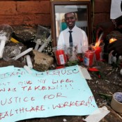 A portrait photo of Dr. Stephen Mogusu, who died due to the coronavirus disease, is seen among candles during a vigil outside the Ministry of Health offices in Nairobi, Kenya on December 9, 2020. A portrait photo of Dr. Stephen Mogusu, who died due to the coronavirus disease, is seen among candles during a vigil outside the Ministry of Health offices in Nairobi, Kenya on December 9, 2020.